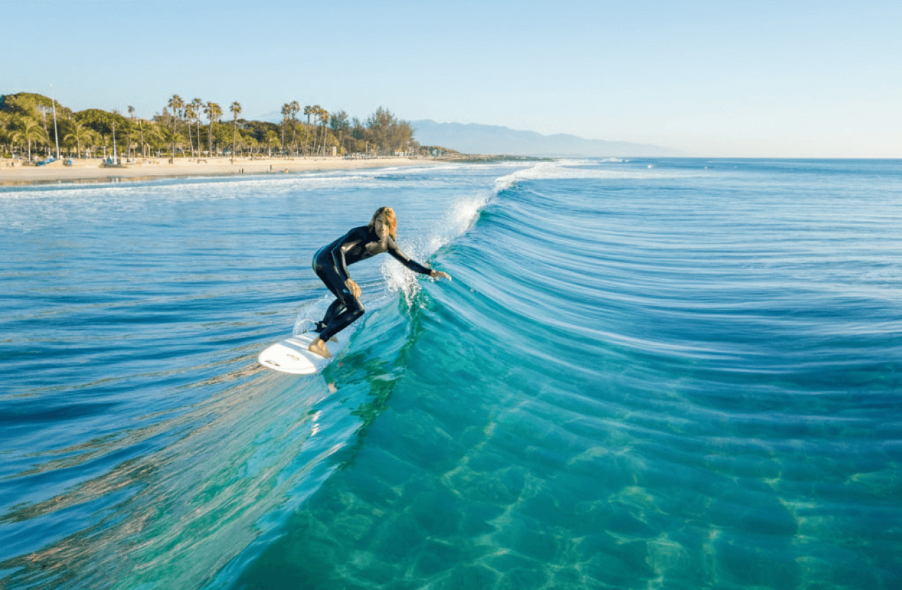 A man skillfully riding a blue ocean wave while surfing