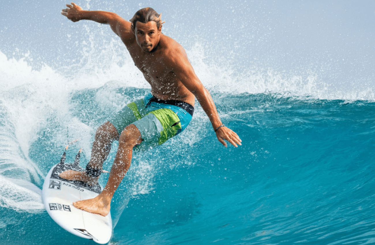 A surfer riding a wave off one of the beautiful Koh Phangan beaches
