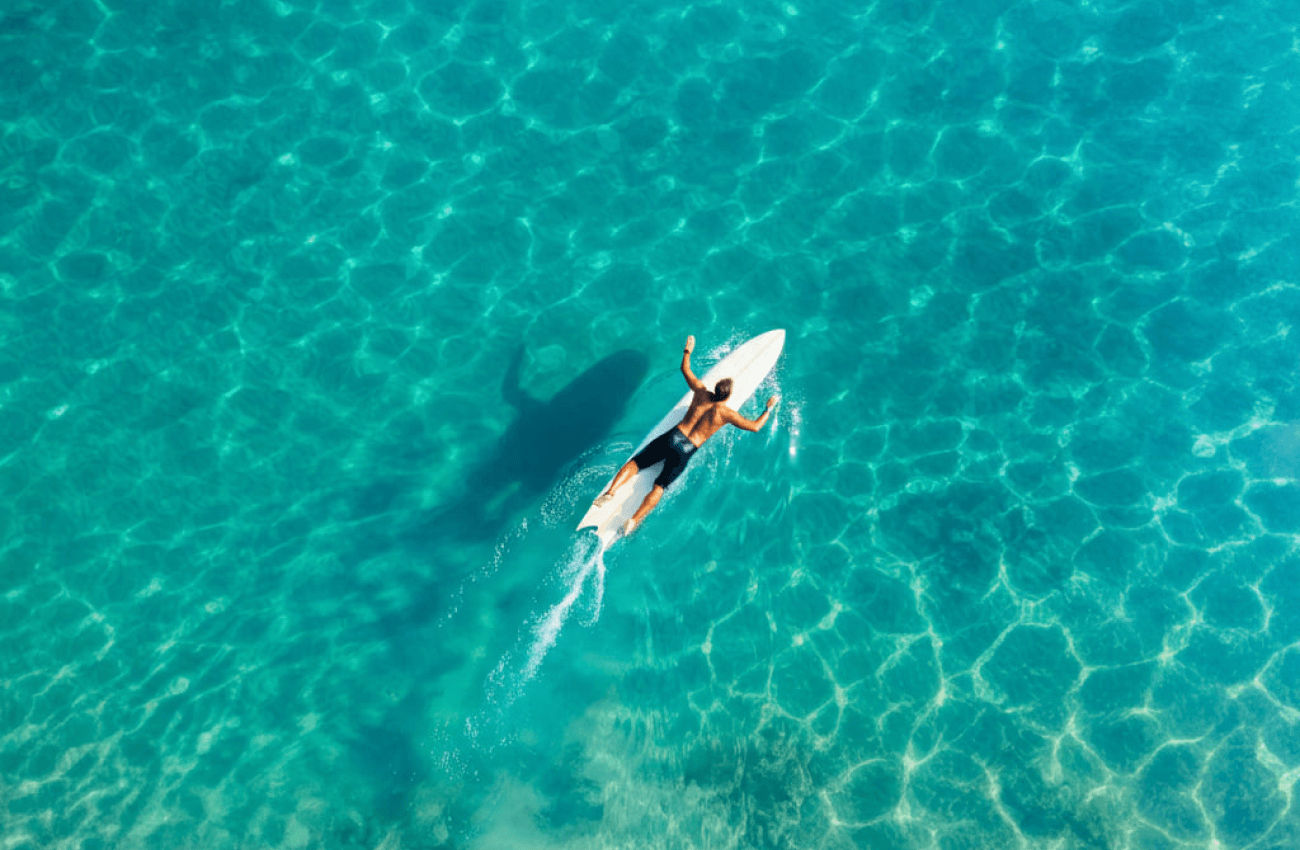 A man on a hydrofoil board performing a surf above water