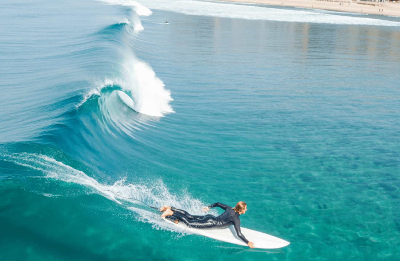 A man focused on riding a wave during a surf session in Phuket