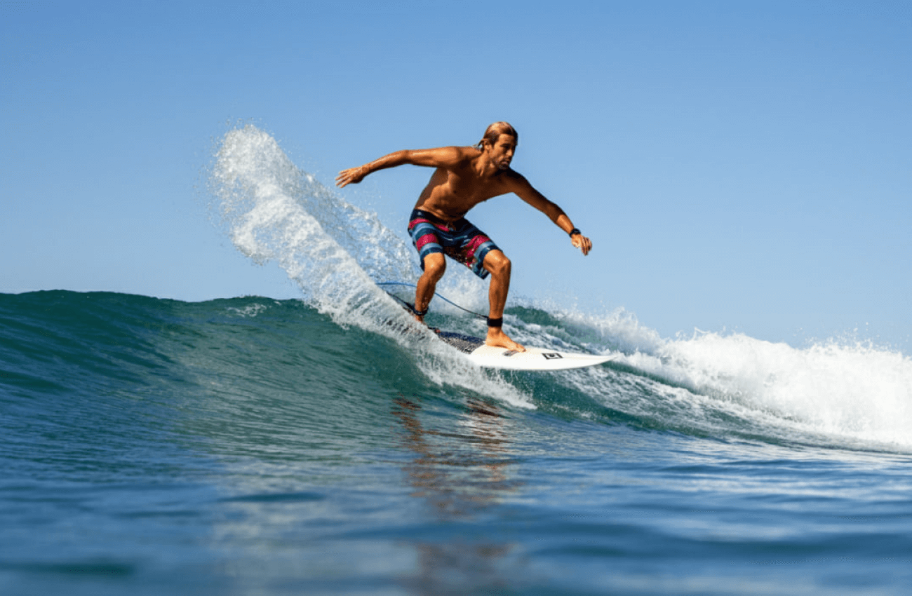 A surfer enjoying the warm waters while surfing in Thailand