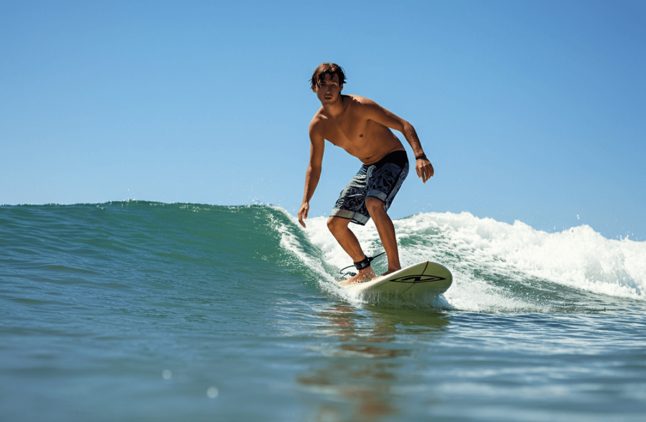 A man surfing in the waters off one of the best beaches in Koh Phangan