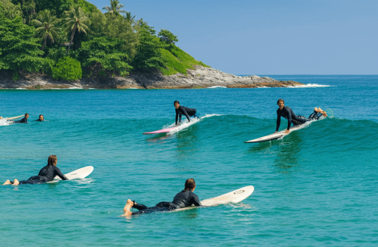 An instructor teaching a group a practical lesson on surfing for beginners