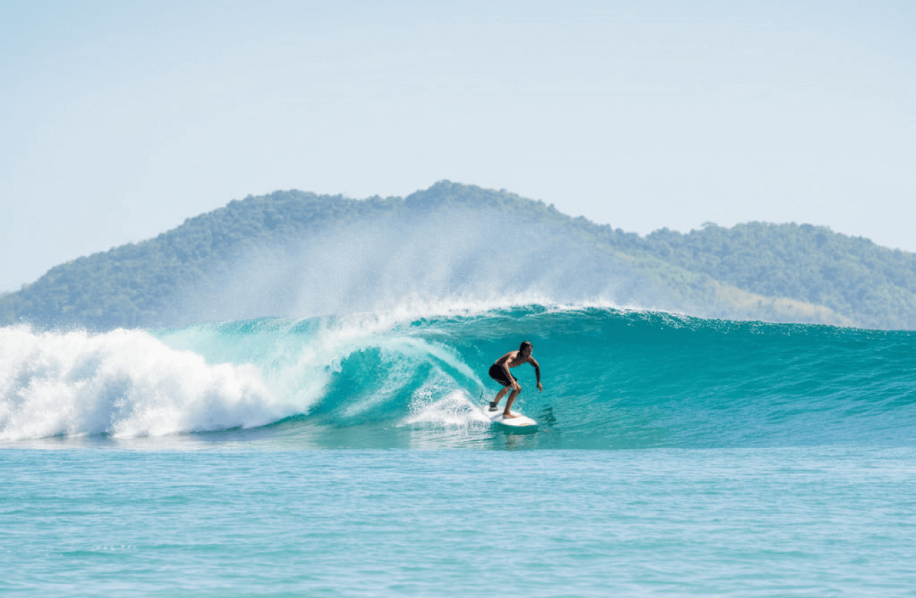 A man gliding smoothly across a wave on a surfboard with a foil